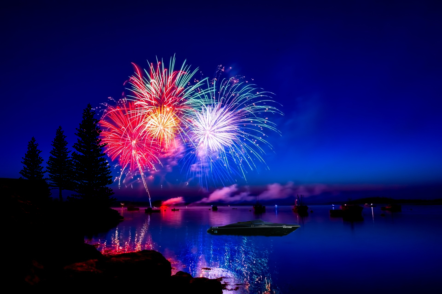 Mystic Boat on Luminary Lake during the Fourth Of July Fireworks show in Woodland Springs Colorado.