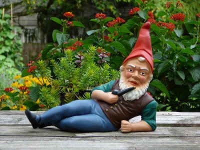 Gnome brazenly lounging about a deck at a human home with magical minty clove pipe in hand.